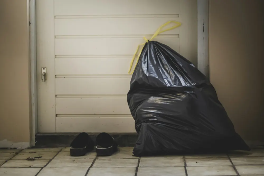 Full black bin liner by a back door
