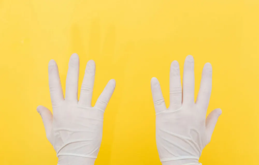 White disposable gloves on a yellow background