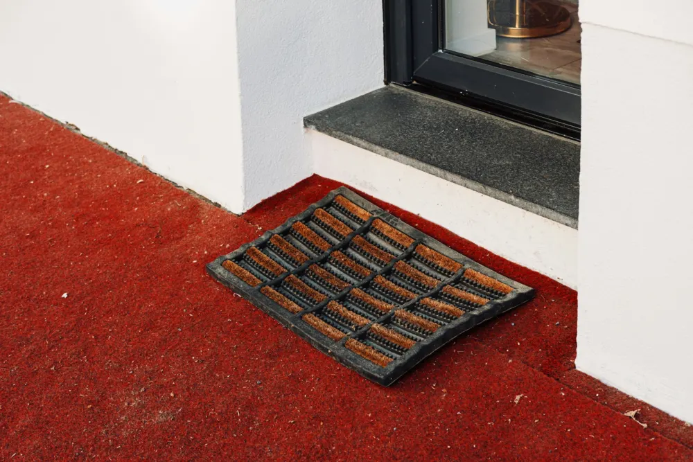 Rubber entrance mat on a red step