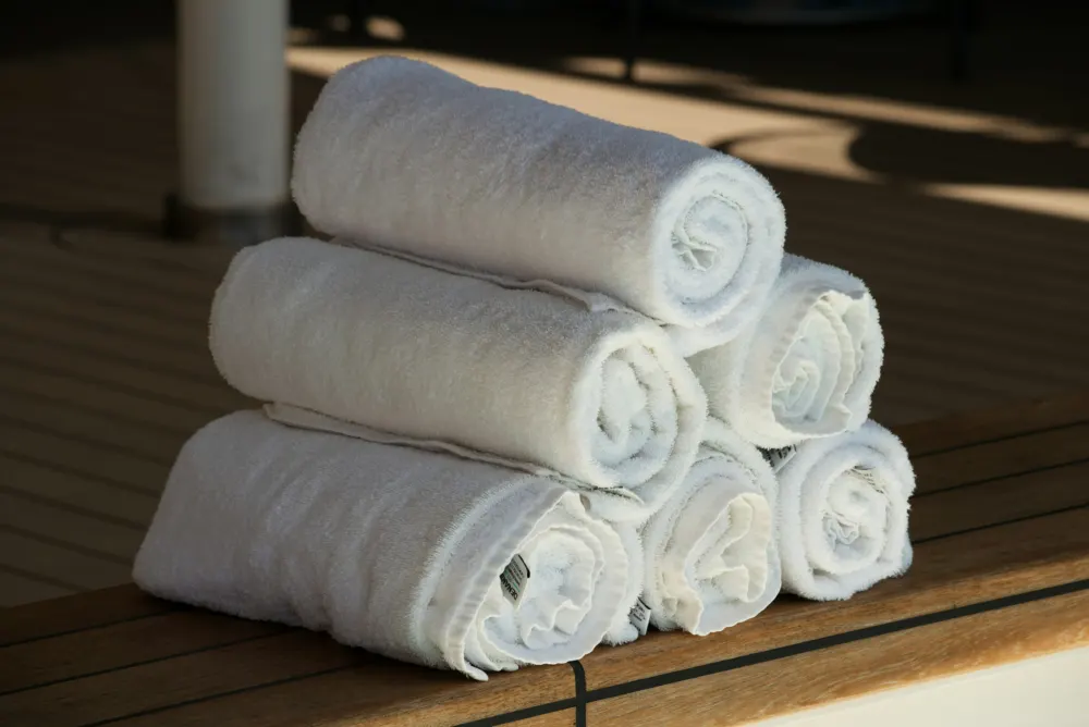 Rolled white towels on a bench